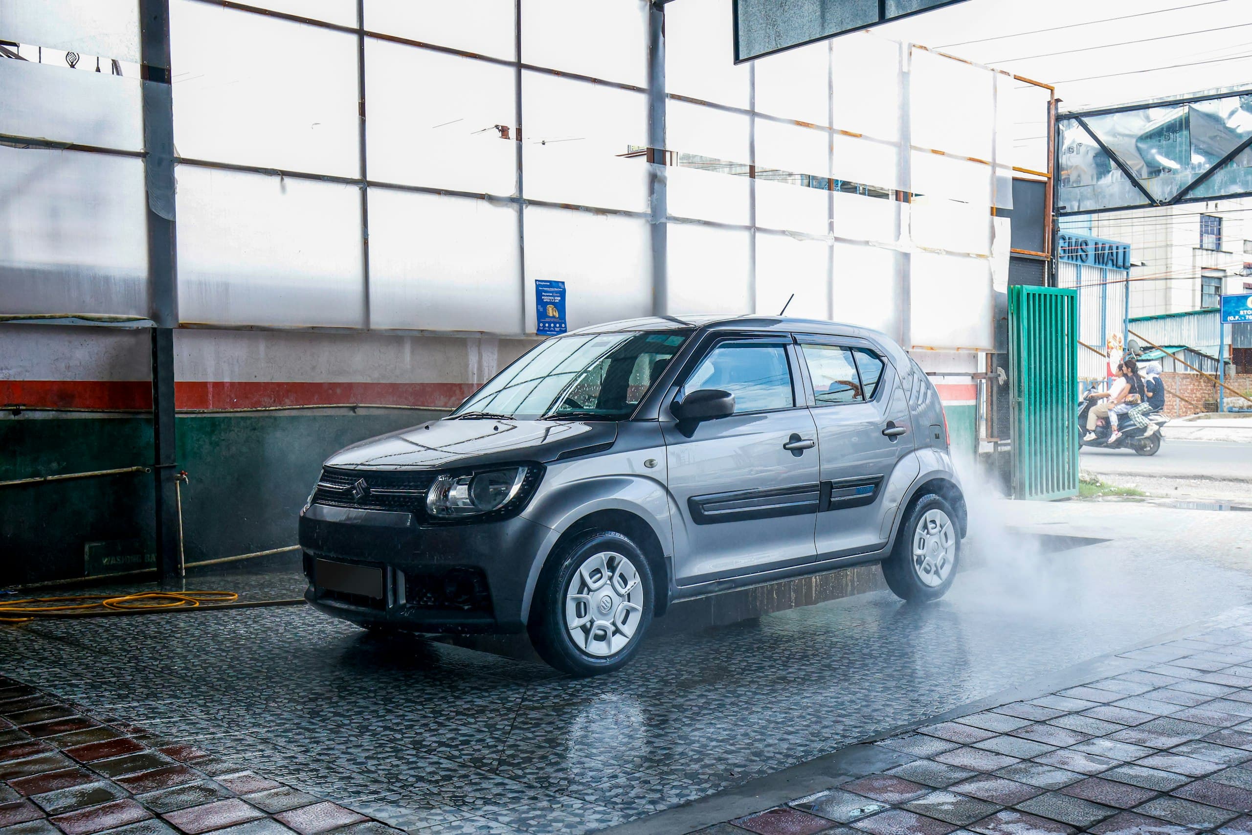 A hatchback being pressure-washed at a wash centre