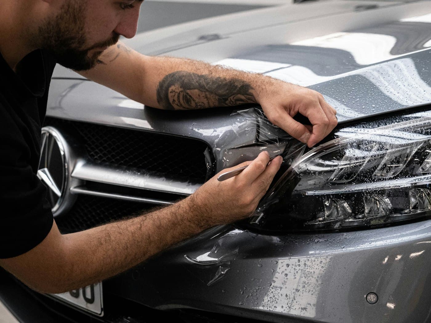 Protective film being fitted around a headlight