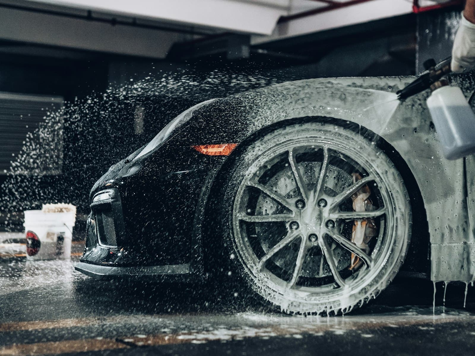 Foam covering the wheel and flank of a dark car